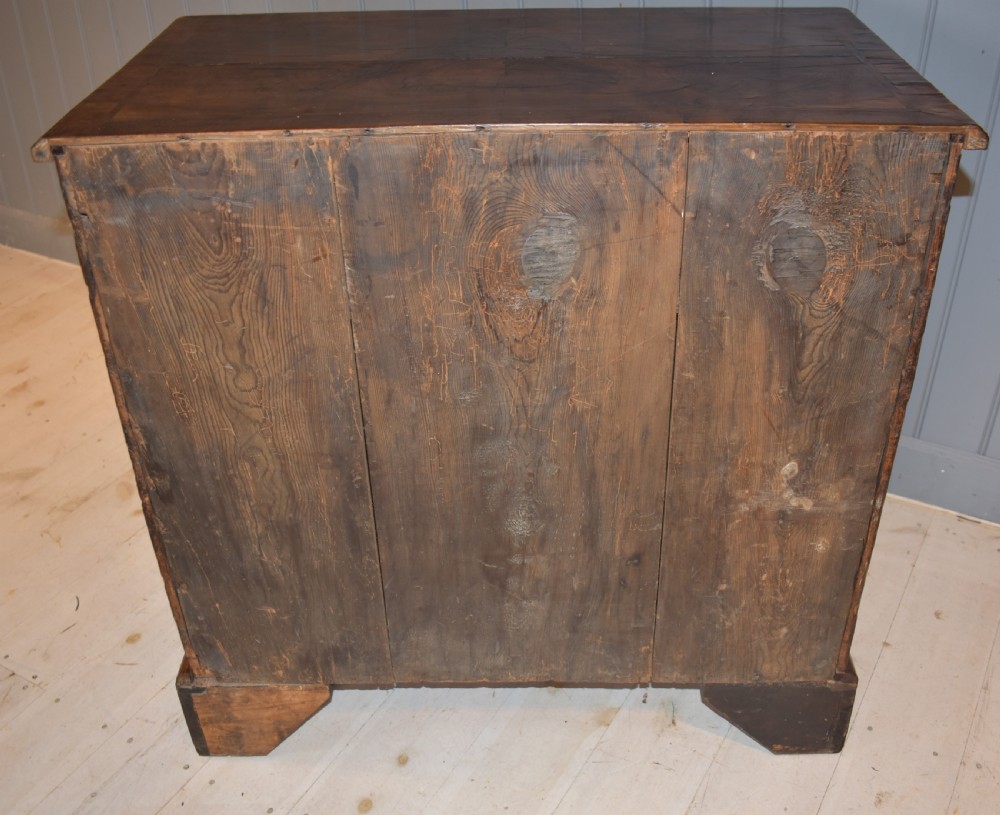 An early 18th-century George I walnut kneehole desk featuring brass handles, a central recessed cupboard, and bracket feet. View XII