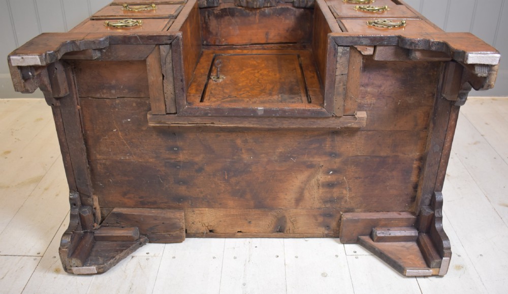An antique Georgian style kneehole desk in burr walnut and burr oak veneers featuring brass handles, a central recessed cupboard, and drawers supported by bracket feet. View IX