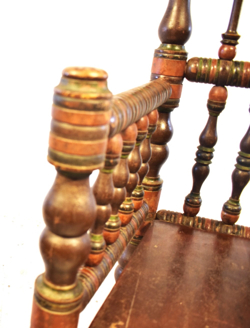 A pair of antique Swedish turned wood armchairs featuring bobbin spindles, tall finials, and dark red and brown paint details. View VII
