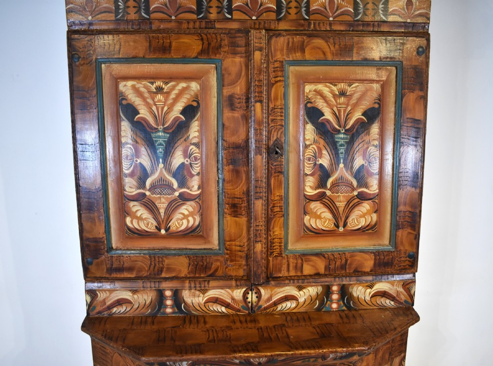A two-tier Swedish painted pine corner cupboard decorated with hand-painted floral motifs and an arched pediment. View III