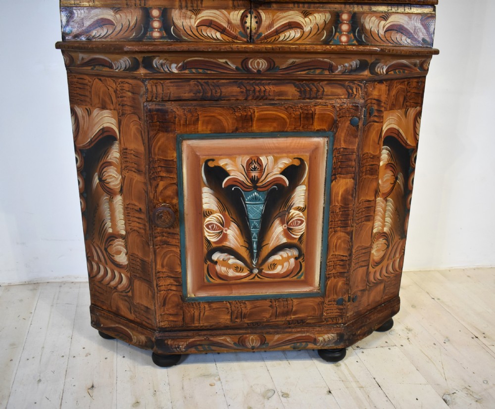 A two-tier Swedish painted pine corner cupboard decorated with hand-painted floral motifs and an arched pediment. View IV