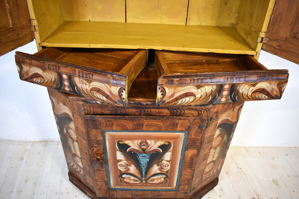 A two-tier Swedish painted pine corner cupboard decorated with hand-painted floral motifs and an arched pediment. View VI