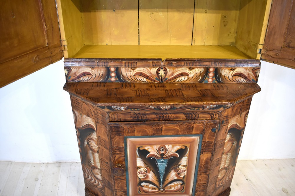 A two-tier Swedish painted pine corner cupboard decorated with hand-painted floral motifs and an arched pediment. View VII