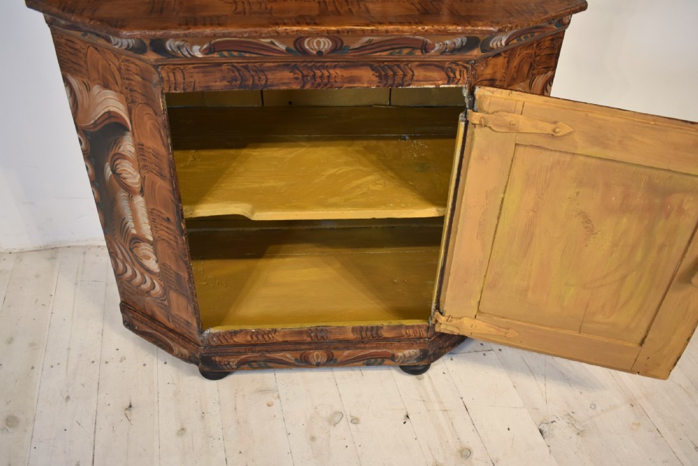 A two-tier Swedish painted pine corner cupboard decorated with hand-painted floral motifs and an arched pediment. View VIII