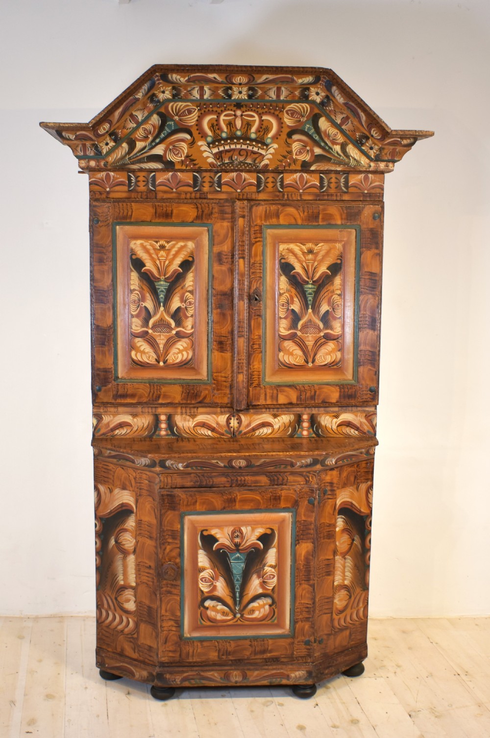 A two-tier Swedish painted pine corner cupboard decorated with hand-painted floral motifs and an arched pediment. View IX