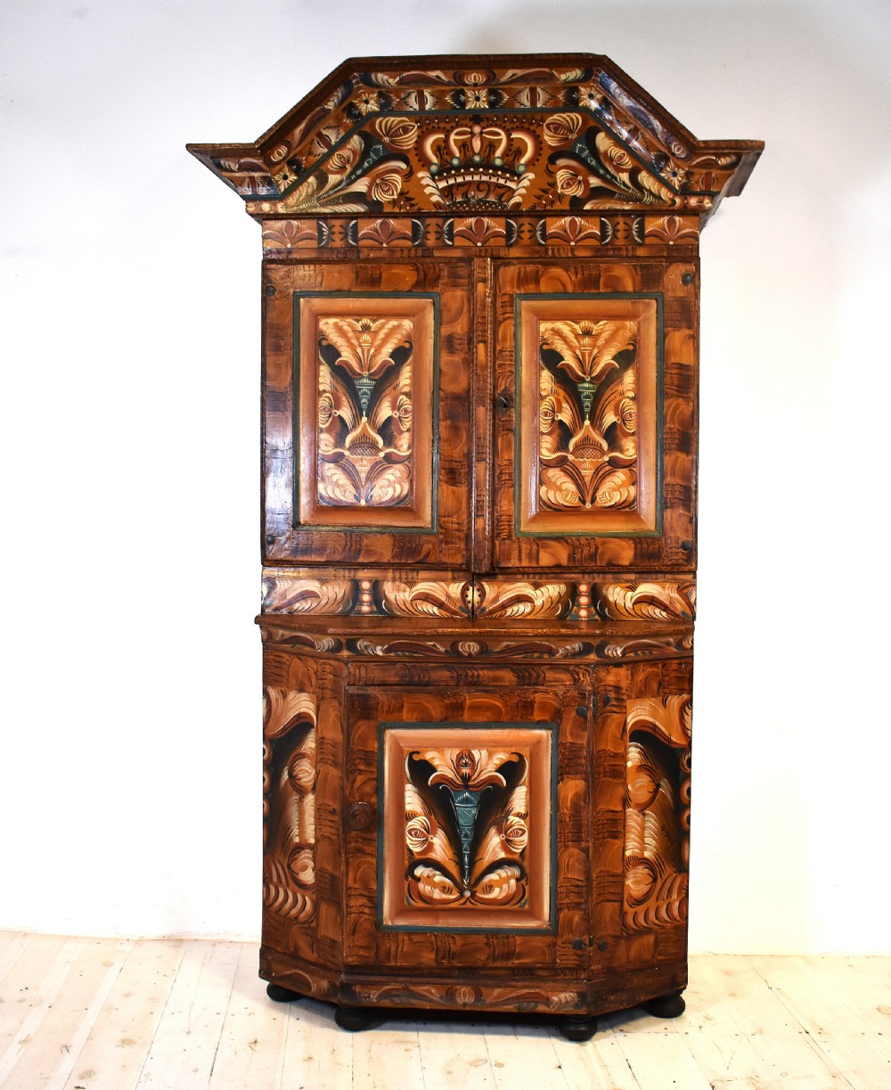 A two-tier Swedish painted pine corner cupboard decorated with hand-painted floral motifs and an arched pediment. View X