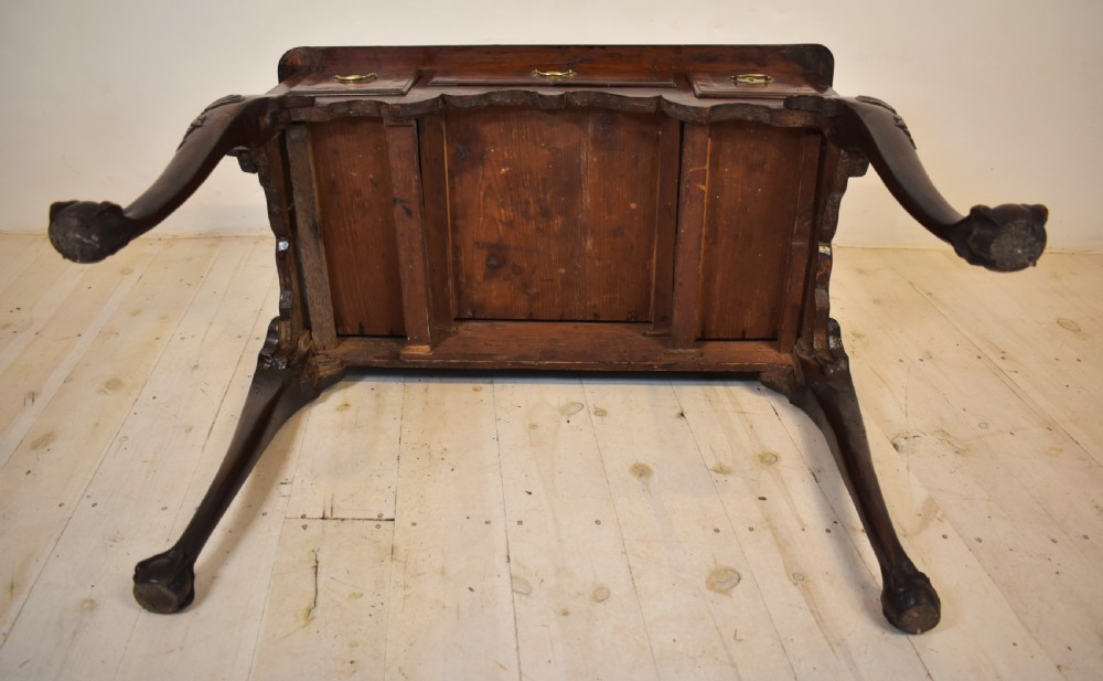 An antique Queen Anne walnut lowboy table featuring three drawers, brass handles, a shaped apron, and carved cabriole legs ending in ball and claw feet. View V