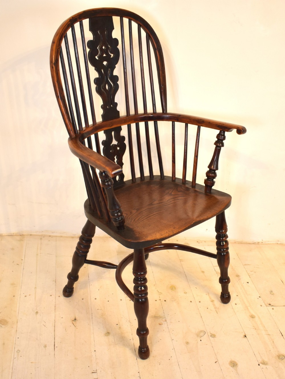 An antique yew wood Windsor armchair featuring a high hoop back with a decorative pierced splat, turned spindles, a shaped saddle seat, and turned legs joined by a curved stretcher. View VI