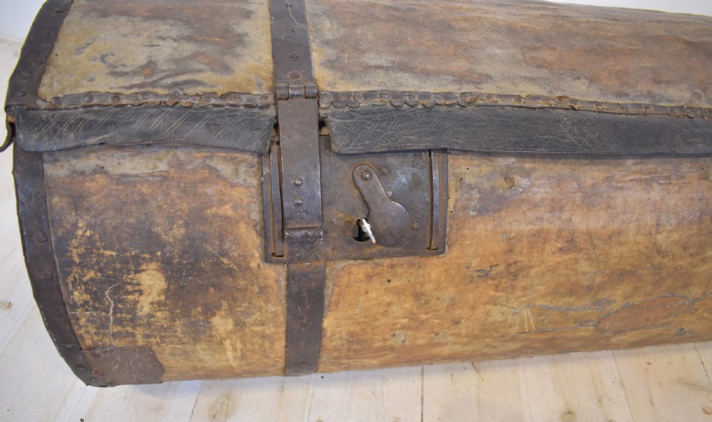 An antique cylindrical hide-covered coffer bound with dark leather trim and heavy iron bands with side handles. View III