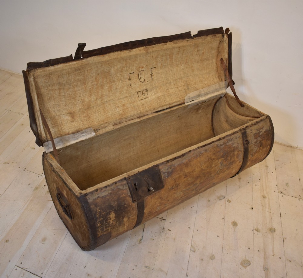 An antique cylindrical hide-covered coffer bound with dark leather trim and heavy iron bands with side handles. View IV