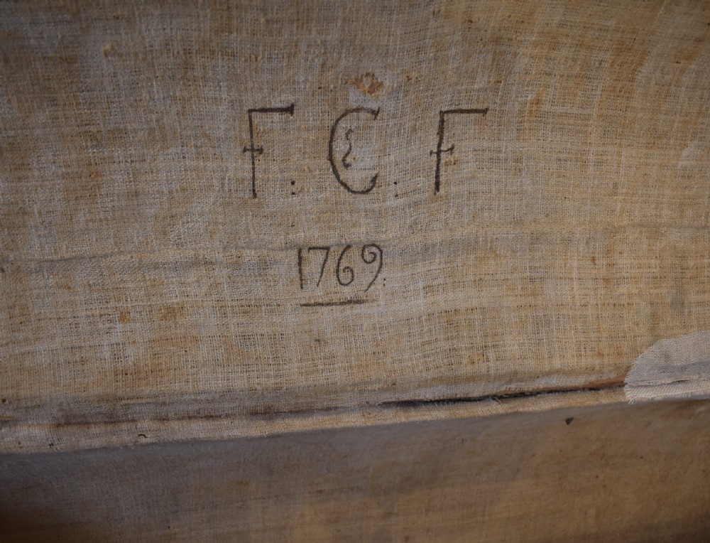 An antique cylindrical hide-covered coffer bound with dark leather trim and heavy iron bands with side handles. View V