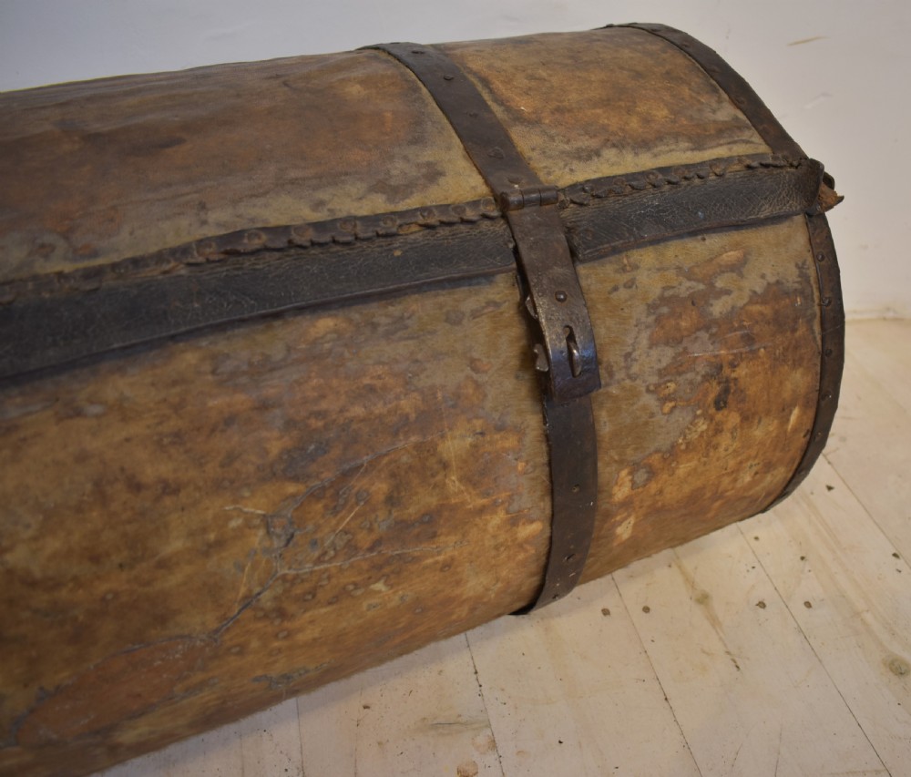 An antique cylindrical hide-covered coffer bound with dark leather trim and heavy iron bands with side handles. View VII
