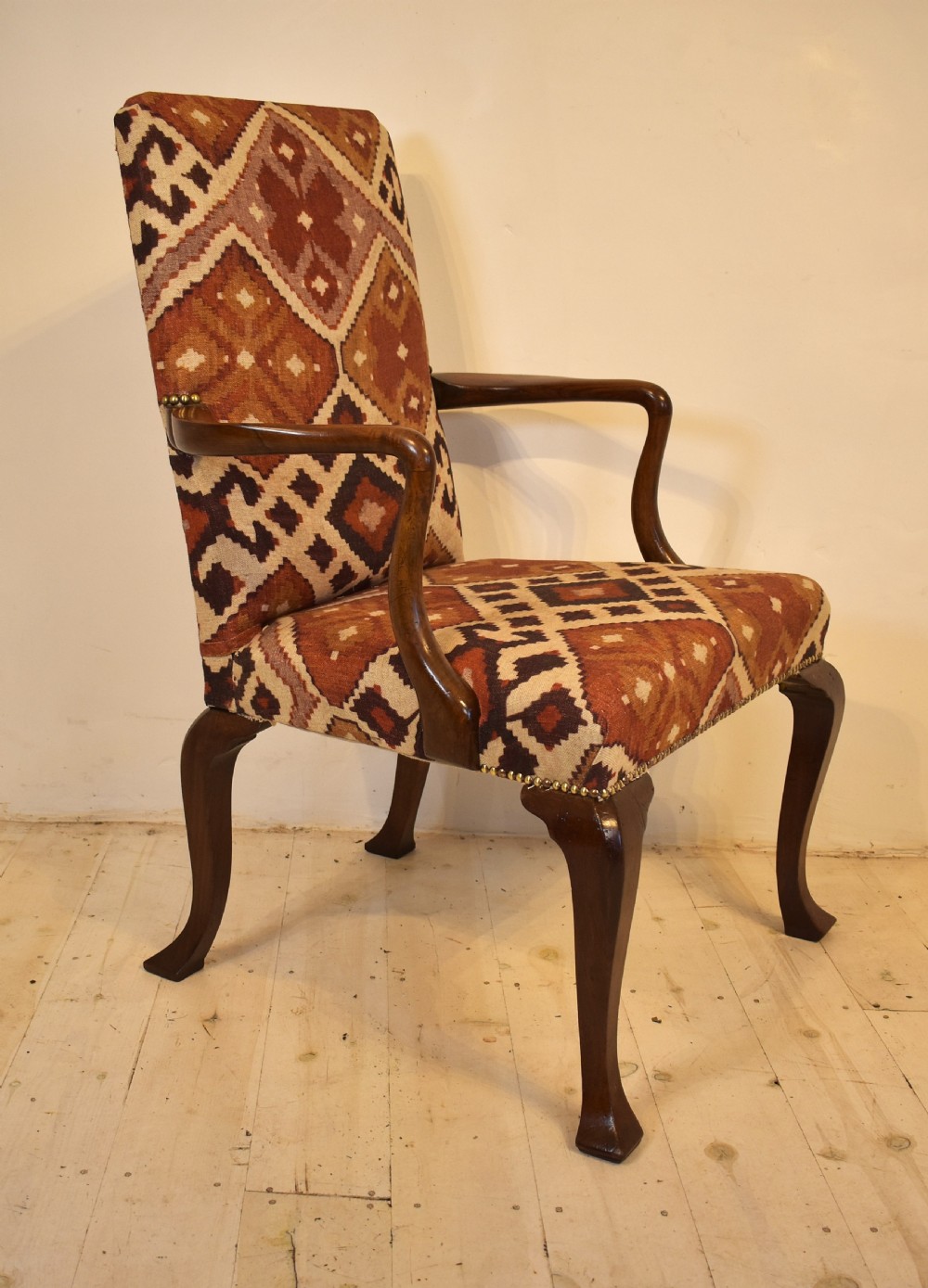 A walnut open armchair with cabriole front legs, shaped wooden arms, brass studding, and geometric terracotta tapestry upholstery. View II