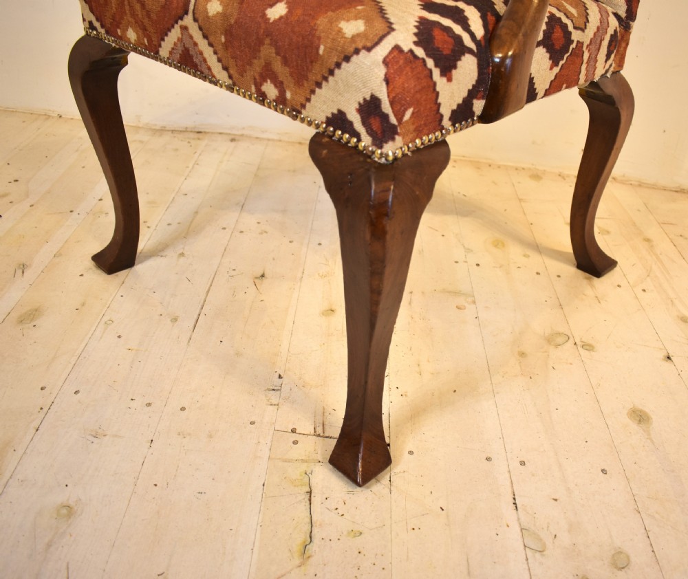 A walnut open armchair with cabriole front legs, shaped wooden arms, brass studding, and geometric terracotta tapestry upholstery. View III