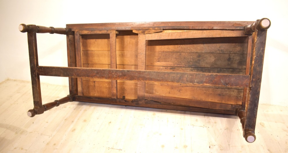 A rustic wooden farmhouse dining table featuring a plank top, a single side drawer, turned legs, and an H-stretcher base. View VII