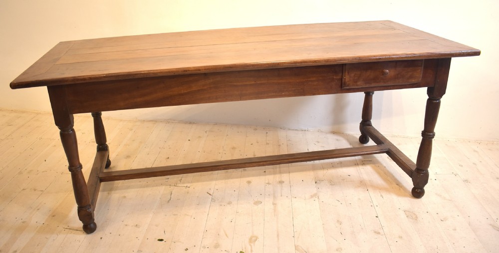 A rustic wooden farmhouse dining table featuring a plank top, a single side drawer, turned legs, and an H-stretcher base. View VIII
