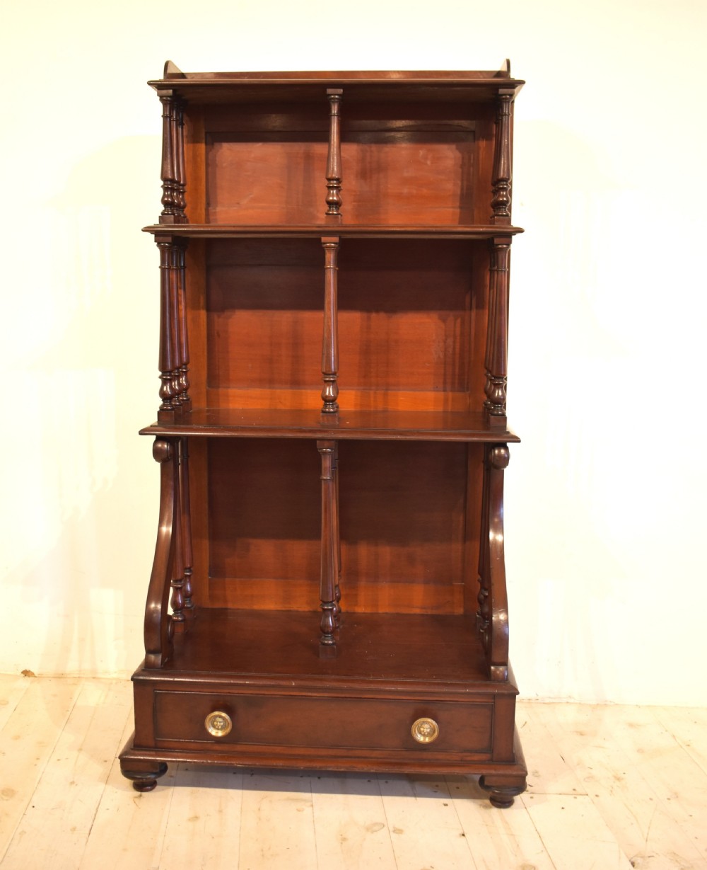 A dark mahogany waterfall bookcase featuring four graduated open shelves supported by turned spindles, curved side supports, and a base drawer with two brass knobs. View II