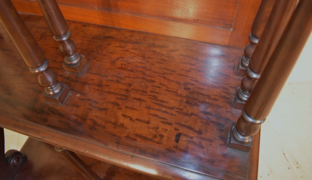 A dark mahogany waterfall bookcase featuring four graduated open shelves supported by turned spindles, curved side supports, and a base drawer with two brass knobs. View VIII