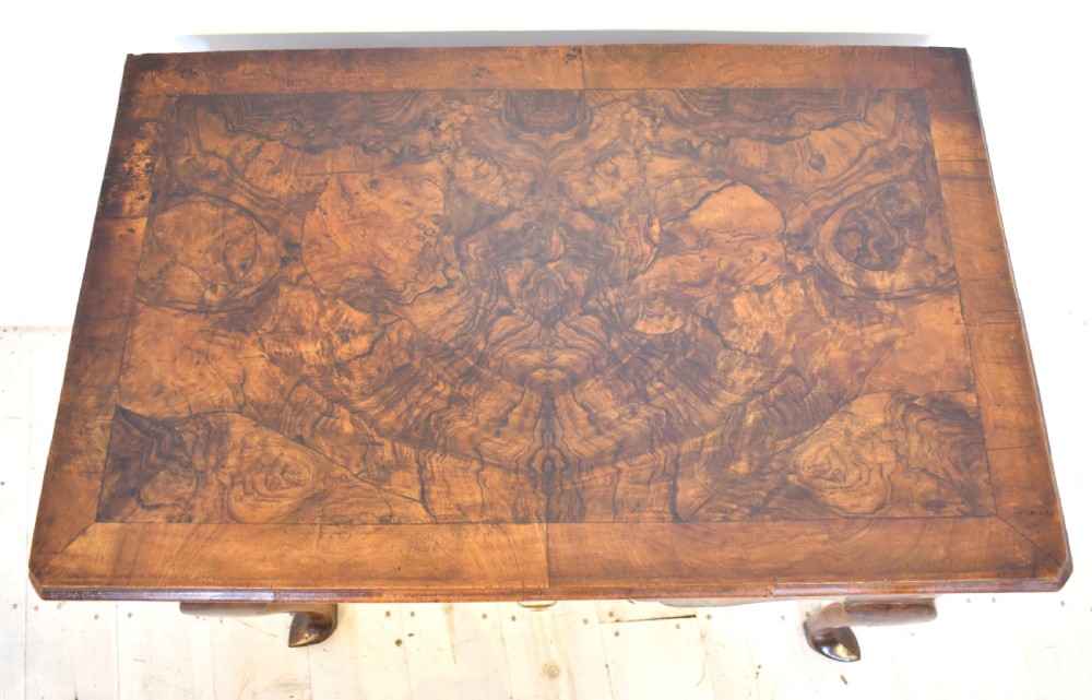 An antique Queen Anne style walnut lowboy featuring three crossbanded drawers with brass drop handles, a scalloped apron, and slender cabriole legs. View VIII