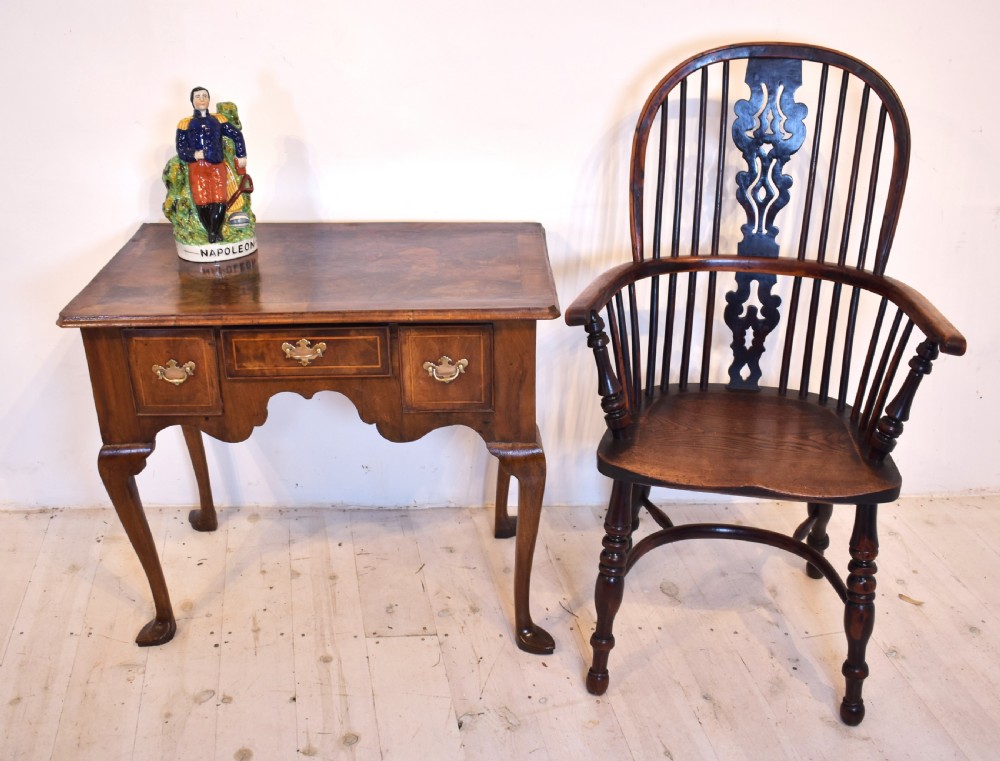 An antique Queen Anne style walnut lowboy featuring three crossbanded drawers with brass drop handles, a scalloped apron, and slender cabriole legs. View IX