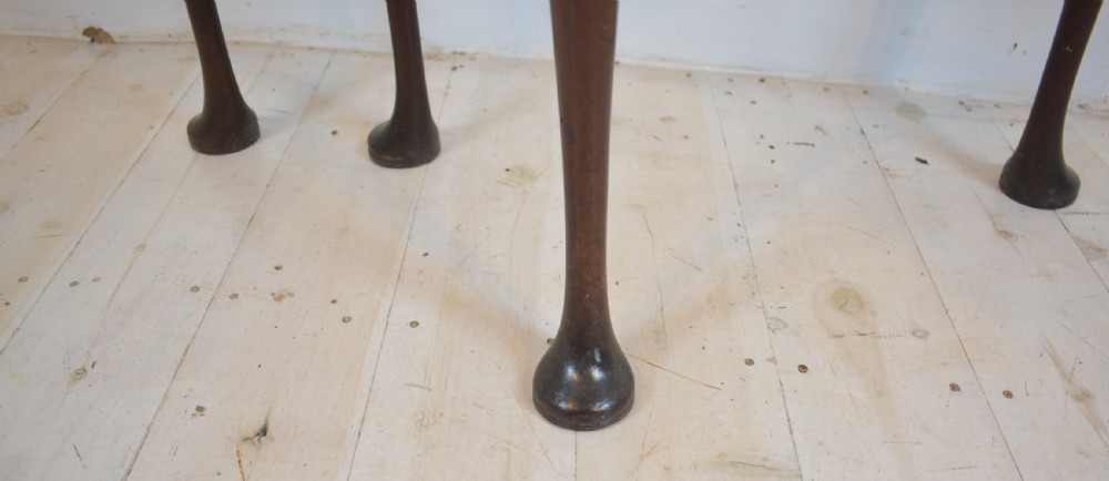An early 18th-century mahogany demi-lune fold-over tea table featuring slender cabriole legs with pad feet and a central brass keyhole escutcheon. View V