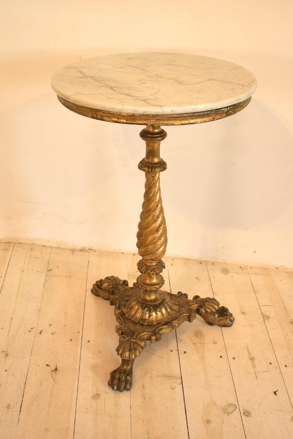 An antique giltwood tripod side table featuring a circular white marble top supported by a spiral twist column and three carved paw feet. View II