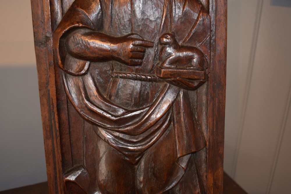 A pair of 17th-century rectangular dark oak timber panels featuring hand-carved relief figures of saints with Latin inscriptions. View X