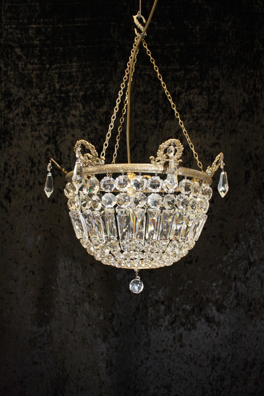 Bag chandelier with leaf decoration around the top.