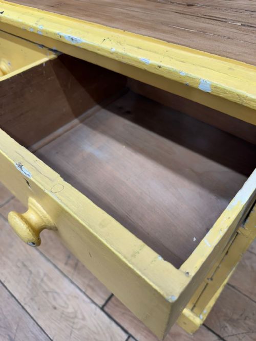 fig 3. An antique yellow painted pine chest of drawers featuring two short drawers over two long drawers with matching turned wooden knobs and a solid plinth base.