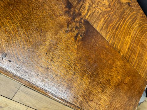 fig 4. An antique carved oak side table featuring turned legs, a single carved drawer with brass handles, and lower stretchers.