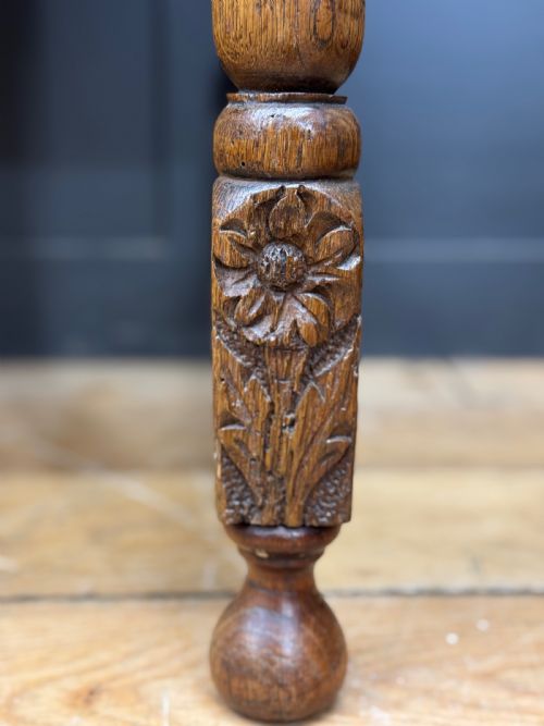 fig 5. An antique carved oak side table featuring turned legs, a single carved drawer with brass handles, and lower stretchers.