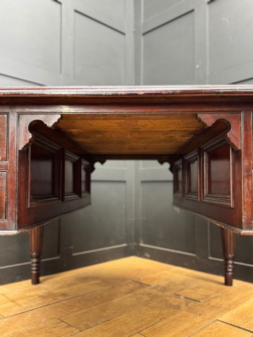fig 1. A dark mahogany partners desk with fluted turned legs, panelled sides, and multiple drawers fitted with brass handles.