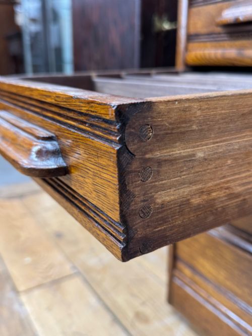 fig 4. An Edwardian oak roll top pedestal desk featuring a flexible wooden tambour cover and twin drawer pedestals with carved handles.