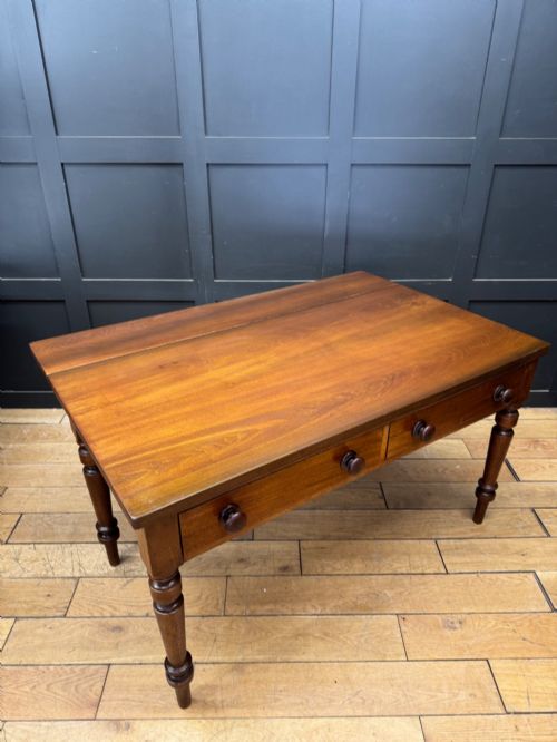 fig 1. A Victorian mahogany writing table featuring two front drawers with wooden turned knobs, four turned legs, and a drop-leaf panel.