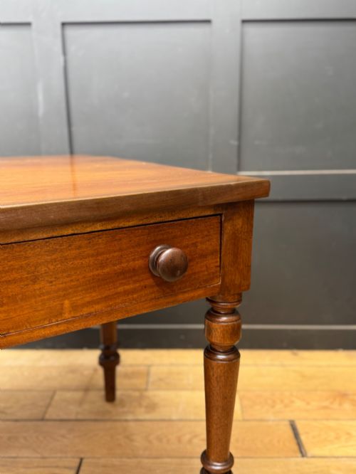 fig 3. A Victorian mahogany writing table featuring two front drawers with wooden turned knobs, four turned legs, and a drop-leaf panel.