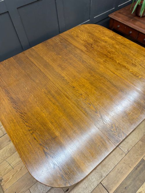 fig 2. An Edwardian solid oak gateleg dining table with fully extended drop leaves, turned baluster legs, and lower stretchers.