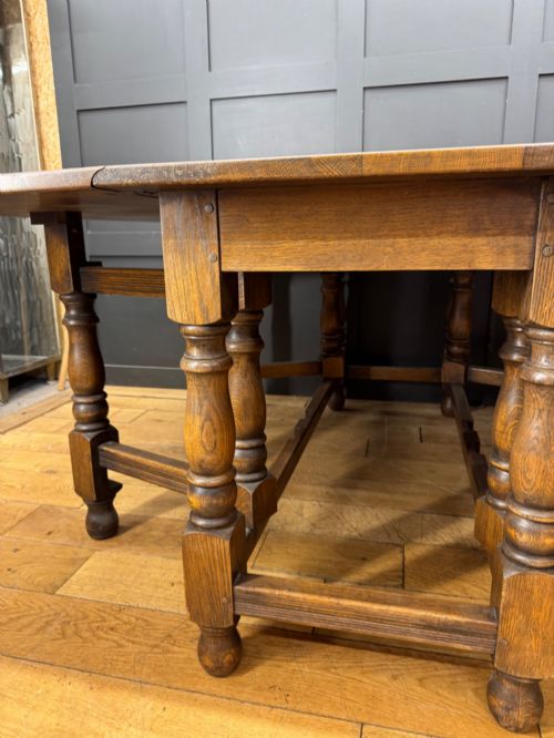 fig 3. An Edwardian solid oak gateleg dining table with fully extended drop leaves, turned baluster legs, and lower stretchers.
