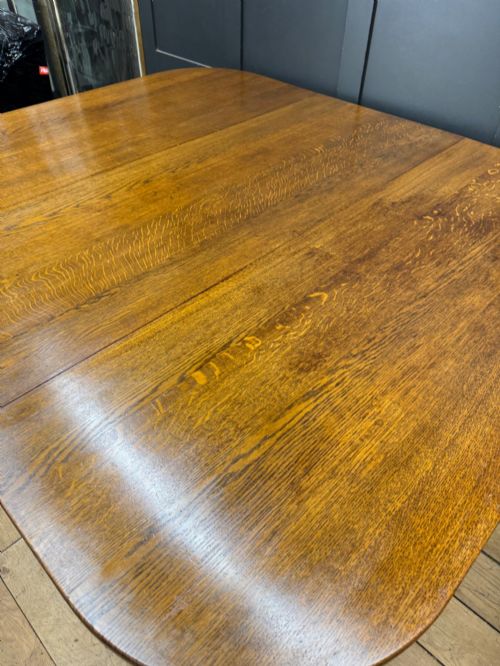 fig 5. An Edwardian solid oak gateleg dining table with fully extended drop leaves, turned baluster legs, and lower stretchers.