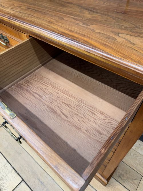 fig 3. A Victorian antique walnut chest featuring two short over three long drawers with ornate brass handles and reeded drawer fronts resting on a solid plinth base.
