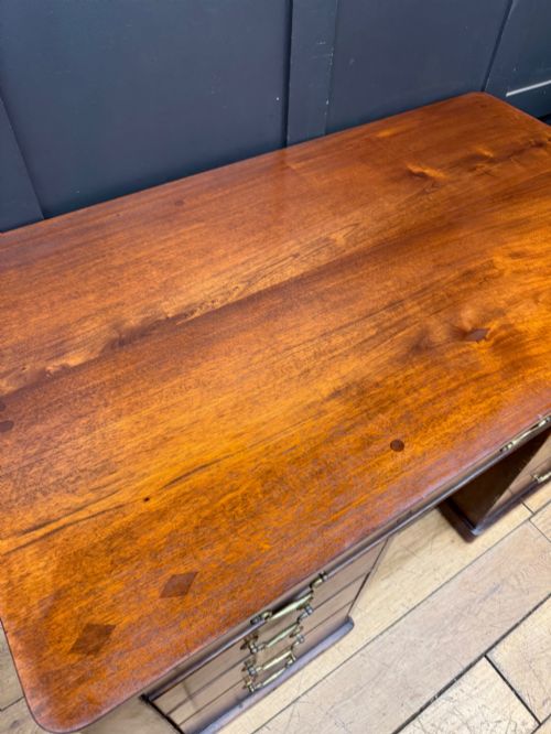 fig 5. An antique mahogany pedestal desk featuring three frieze drawers, twin drawer pedestals with brass drop handles, and a solid plinth base.