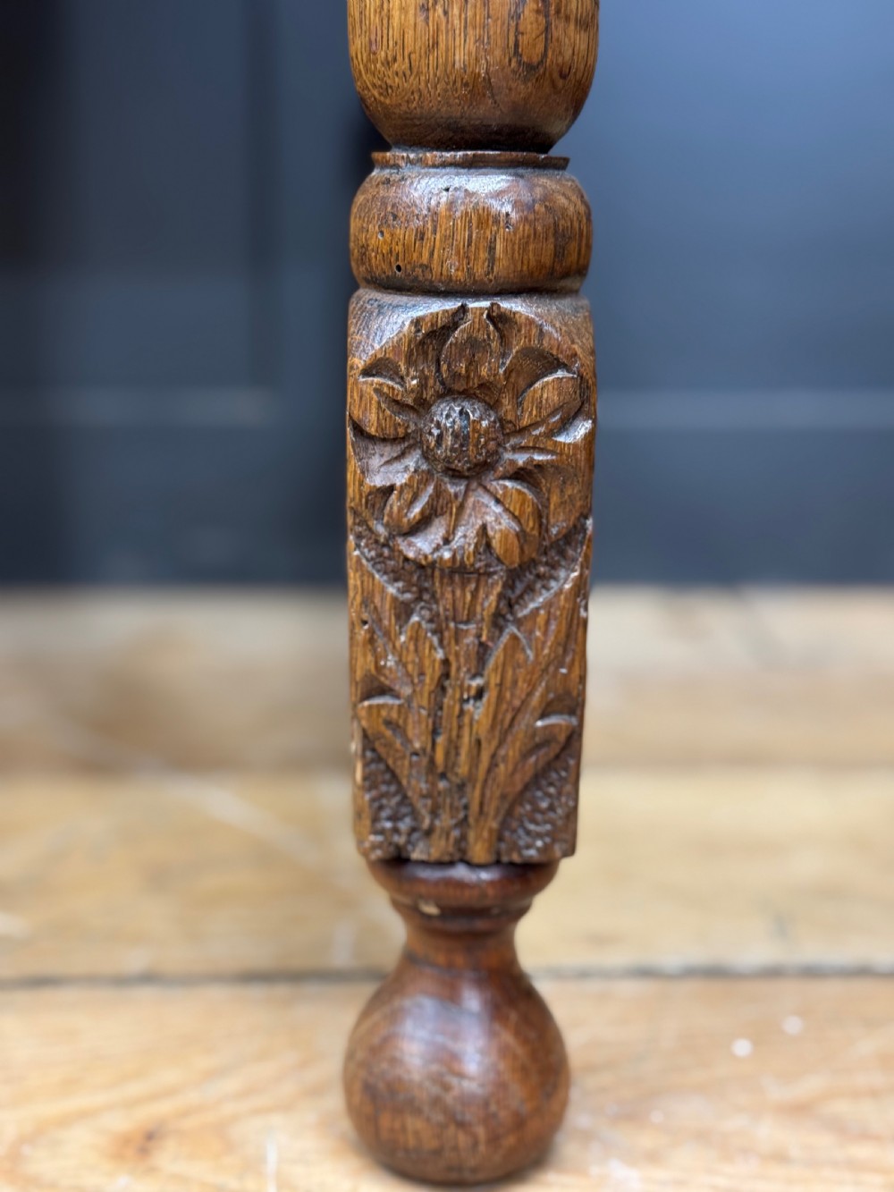 An antique carved oak side table featuring turned legs, a single carved drawer with brass handles, and lower stretchers. View VI