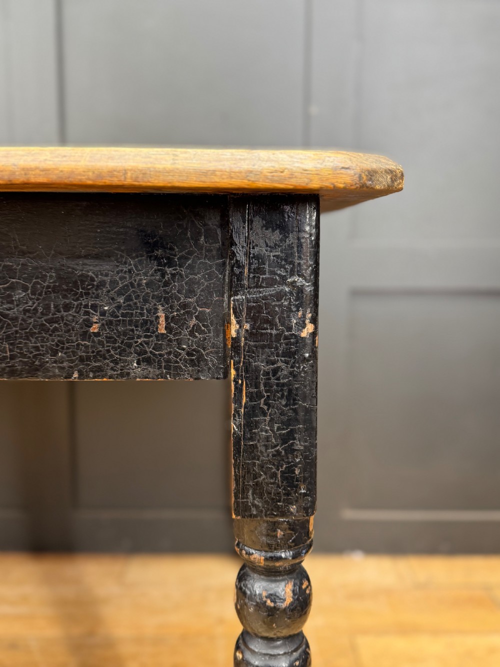 A Victorian pine kitchen table featuring a scrubbed natural wooden top and a distressed black painted frame with turned legs. View IV