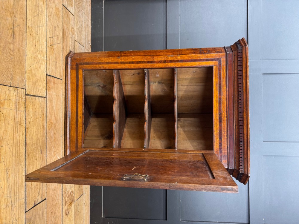 A Georgian oak wall corner cupboard featuring a single panel door with central shell marquetry inlay, crossbanded borders, and dentil moulding along the top cornice. View II