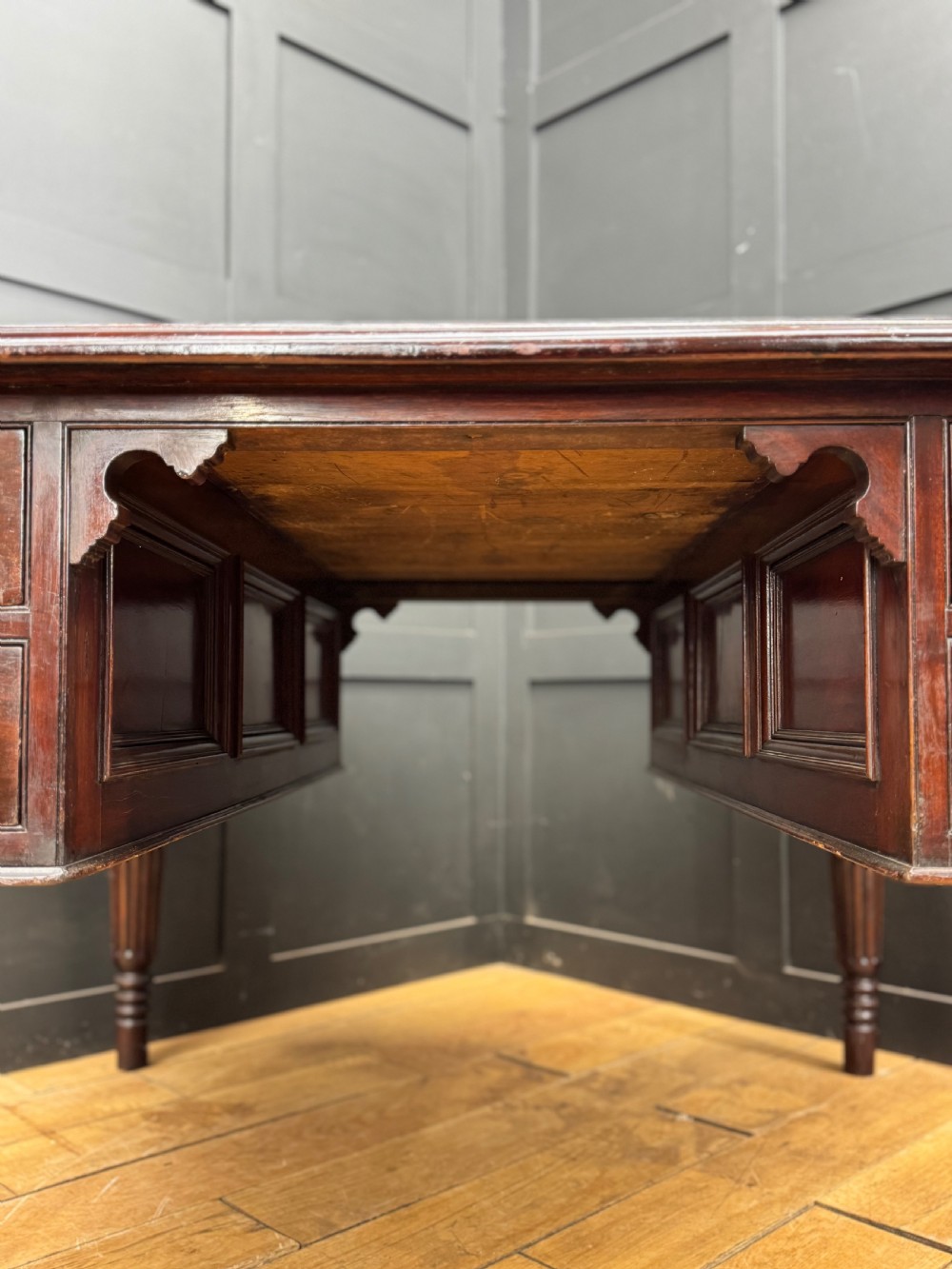 A dark mahogany partners desk with fluted turned legs, panelled sides, and multiple drawers fitted with brass handles. View II