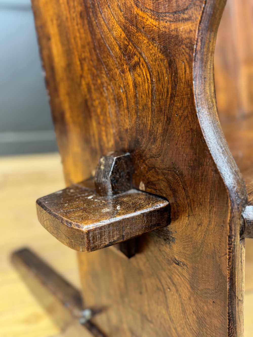 A curved antique elm wooden settle pew featuring a slatted high back, shaped side wings, and visible pegged joinery. View VIII