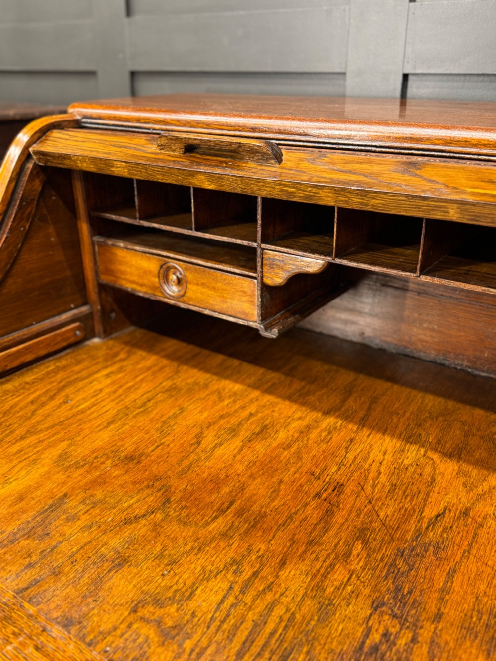 An Edwardian oak roll top pedestal desk featuring a flexible wooden tambour cover and twin drawer pedestals with carved handles. View II