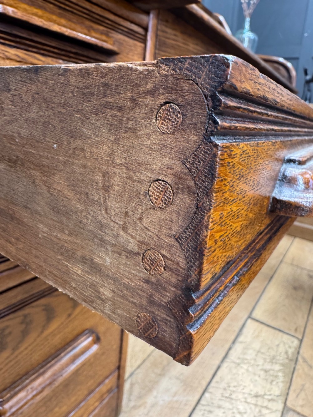An Edwardian oak roll top pedestal desk featuring a flexible wooden tambour cover and twin drawer pedestals with carved handles. View VIII
