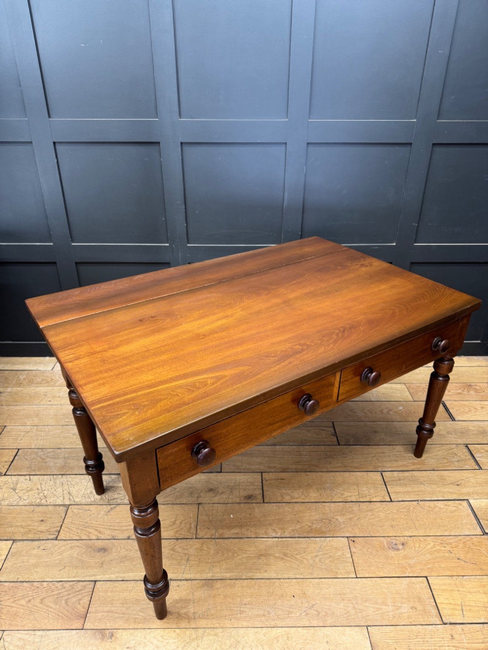 A Victorian mahogany writing table featuring two front drawers with wooden turned knobs, four turned legs, and a drop-leaf panel. View II