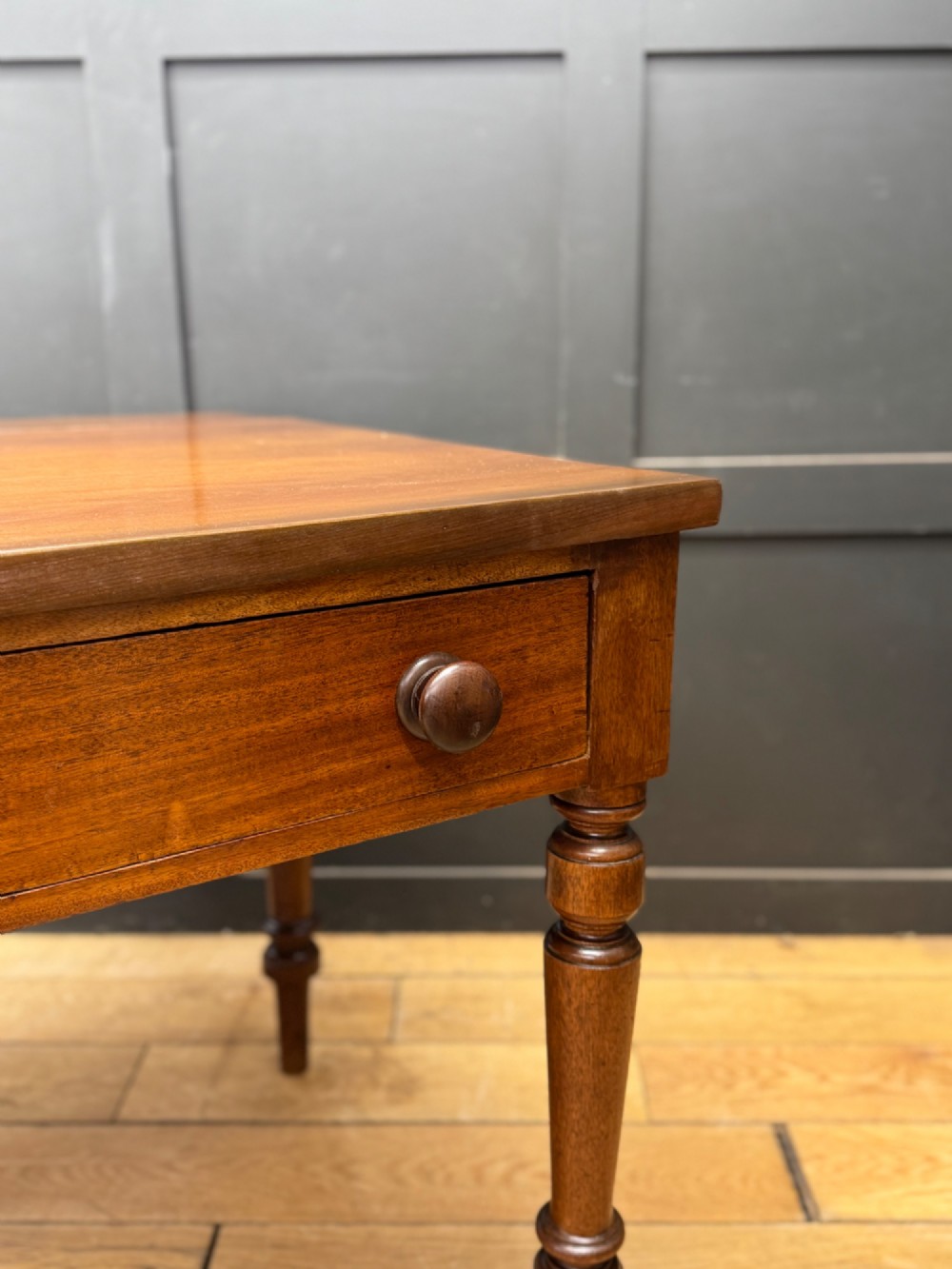 A Victorian mahogany writing table featuring two front drawers with wooden turned knobs, four turned legs, and a drop-leaf panel. View IV