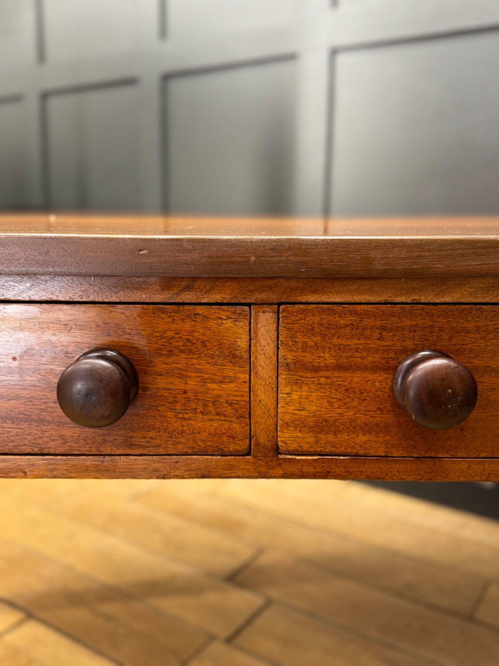 A Victorian mahogany writing table featuring two front drawers with wooden turned knobs, four turned legs, and a drop-leaf panel. View V